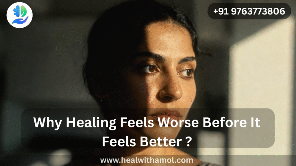 Person sitting alone in soft light reflecting during emotional healing journey