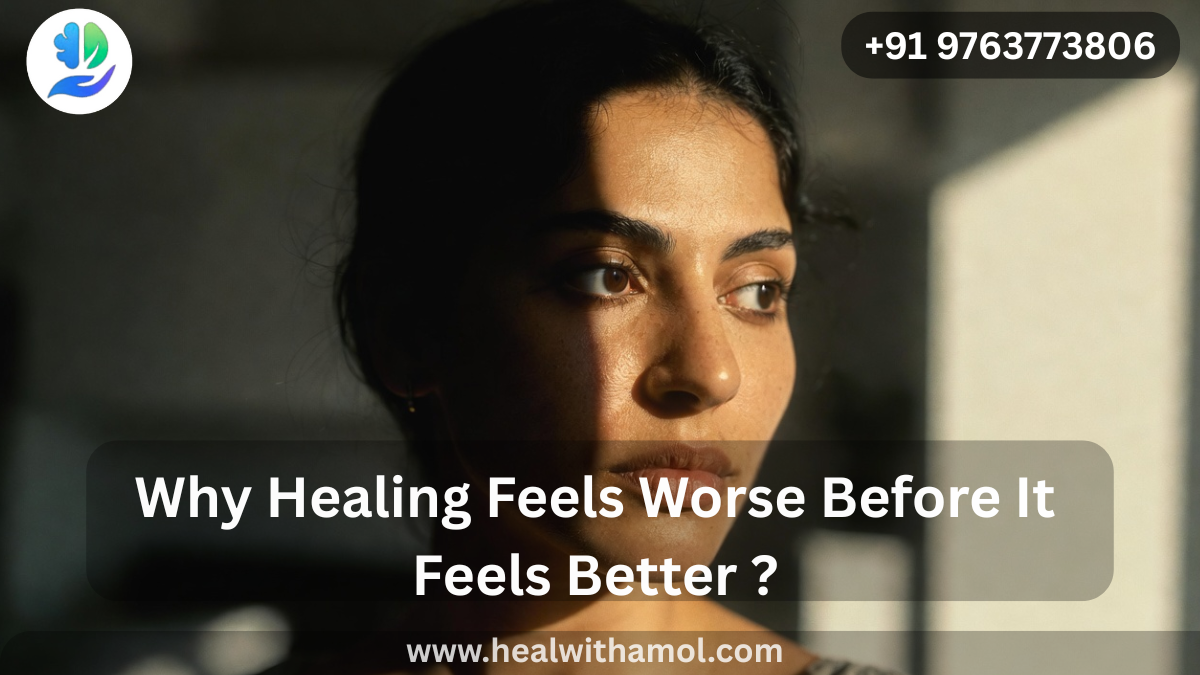 Person sitting alone in soft light reflecting during emotional healing journey